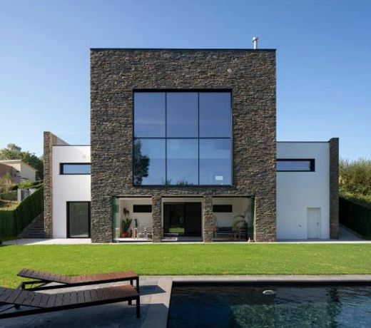 Casa moderna con piscina y vistas al bosque.