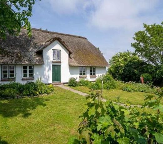 The stylishly restored and thatched holiday home is located on a terp