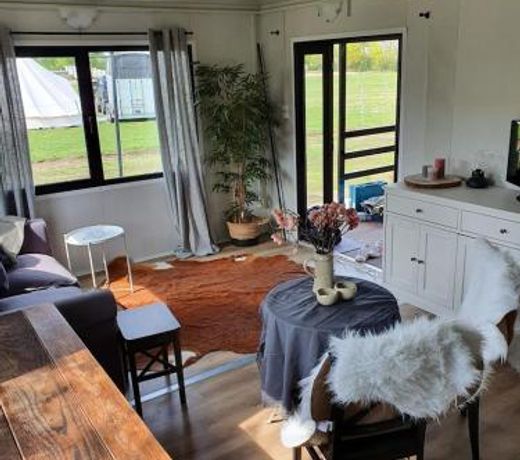 Houten huisje tussen paarden
